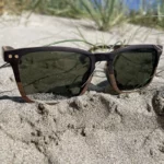 Gros plan sur la monture des lunettes Draken mettant en valeur le contraste entre le noyer clair et l’ébène foncé.