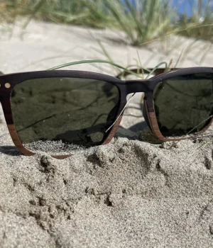 Gros plan sur la monture des lunettes Draken mettant en valeur le contraste entre le noyer clair et l’ébène foncé.