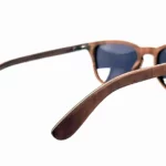 Gros plan sur les montures légères des lunettes Douglas Brown, en bois naturel de noyer, avec protection UV400 catégorie 3.