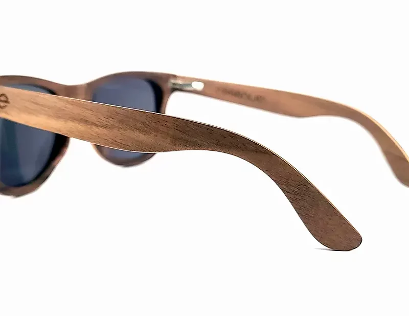 Vue rapprochée des lunettes Howker Grey, présentant des veines naturelles uniques du bois de noyer.