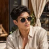 Un modèle portant les lunettes Classic R15 dans un jardin ensoleillé, mettant en valeur un design Clubmaster élégant.