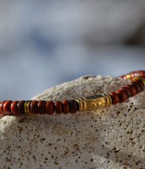 Bracelet en bois d'exception avec médaillon doré, parfait pour sublimer vos tenues quotidiennes ou des occasions spéciales.