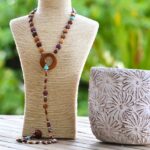 Collier sautoir en bois bicolore Marina fabriqué artisanalement avec des essences de bois nobles comme l’amarante, le mûrier, le néflier et le palissandre.