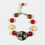 Gros plan des perles en bois soigneusement polies du Bracelet multicolore - Le triskel, révélant la texture et les couleurs naturelles.