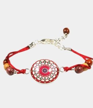 Bracelet cabochon en bois avec perles d'acajou et cabochon en verre mandala rosé, posé sur une surface blanche.