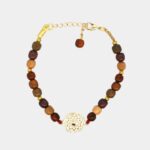 Bracelet multicolore doré Jeanne sur un fond gris, mettant en valeur ses couleurs vives et son design artisanal.