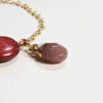 Gros plan sur le médaillon Amarante et la pierre de Quartz du bracelet Junia