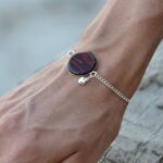 Un bracelet élégant composé d'une chaîne argentée réglable et d'un cabochon en bois d'acajou, parfait pour toute occasion.