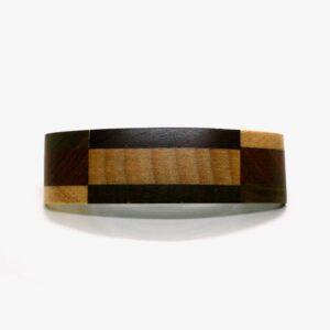 Barrette en bois de marqueterie multicouleur Lise posée sur une surface en bois, 100% fabriquée à la main avec des matières naturelles. Dimensions : 10 cm x 3 cm.