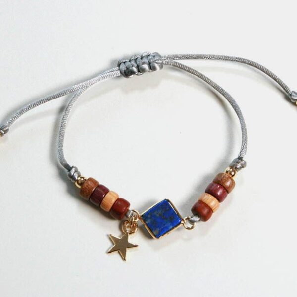 Plan rapproché du bracelet Liz avec perles dorées et étoile dorée, mettant en valeur le savoir-faire artisanal.