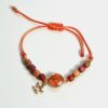 Gros plan sur les perles en bois naturel et la pierre semi-précieuse jaspe du bracelet Love.