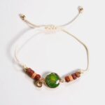 Bracelet femme en pierre de Jaspe Impérial vert avec perles en bois multicolore et médaillon en strass doré sur cordon crème ajustable.