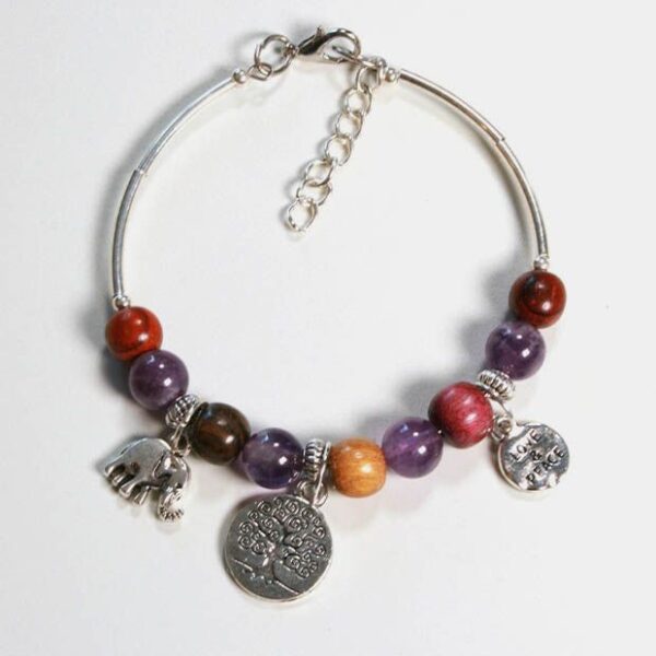 Vue rapprochée des différentes essences de bois et des perles d’améthyste composant le bracelet.