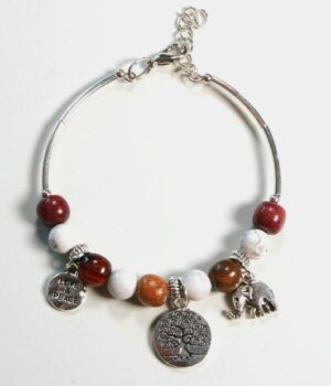 Bracelet jonc en bois Howlite Samia exposé sur un fond blanc, mettant en évidence ses perles naturelles et ses breloques argentées.