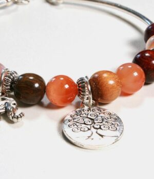 Bracelet jonc en bois précieux avec des perles de Quartz rose, modèle Samia, présenté sur un fond gris.