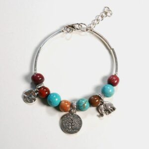 Un bracelet jonc en bois précieux avec des perles en turquoise et des breloques argentées, présenté sur un fond gris.