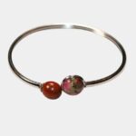 Gros plan sur un bracelet artisanal avec des matériaux naturels : bois d'acajou et pierre de jaspe.