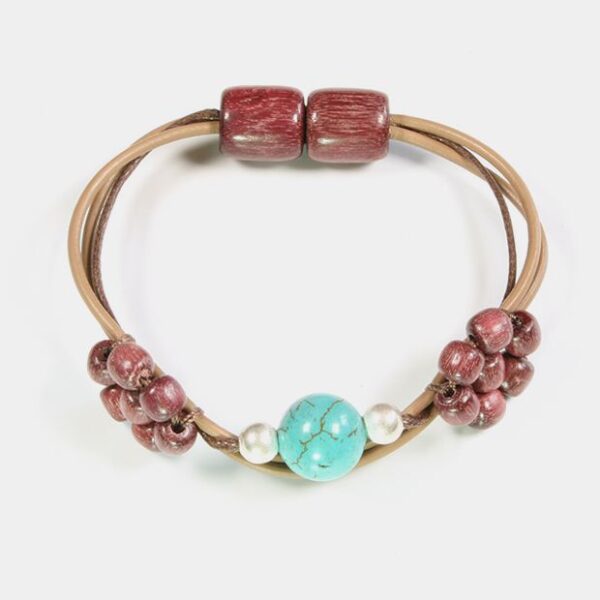 Gros plan sur le bracelet aimanté montrant les petites fleurs et perles argentées.