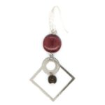 Gros plan sur une boucle pendante élégante avec perle en bois et fermoir en silicone.