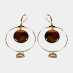 Bijou élégant composé d'un anneau doré suspendant un élément central en bois naturel.