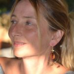 Boucles d'oreilles créoles dorées avec filigrane en motif lotus et perle en bois d'amarante.