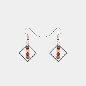 Gros plan sur une paire de boucles d’oreilles légères et élégantes en bois naturel et métal argenté.