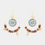 Design artisanal de boucles d'oreilles créoles avec pendentif en verre turquoise.