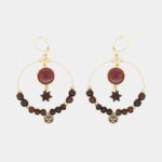 Gros plan sur des boucles d’oreilles pendantes écologiques en bois précieux et métal doré