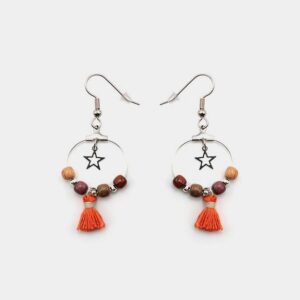 Boucles d’oreilles en bois précieux avec étoile filigrane argentée, sur fond blanc.