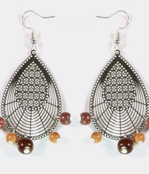 Gros plan sur les détails minutieux du filigrane argenté et des bois colorés des boucles d’oreilles Dorianne.