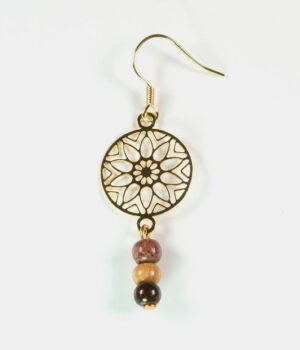 Vue rapprochée des boucles d'oreilles en bois Paola avec un motif étoile dorée.