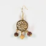 Présentation des boucles d'oreilles rosace doré avec d'autres bijoux en bois de la collection Essenciel.