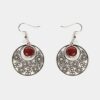 Gros plan sur une paire de boucles d'oreilles multicolores Noélie avec un design créole et des perles en bois précieux.