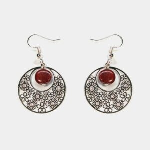 Gros plan sur une paire de boucles d'oreilles multicolores Noélie avec un design créole et des perles en bois précieux.