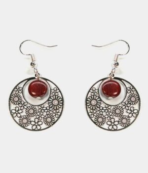 Gros plan sur une paire de boucles d'oreilles multicolores Noélie avec un design créole et des perles en bois précieux.