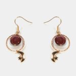 Détail des boucles d'oreilles Angel en bois d'Amarante montrant la texture et la finition dorée.