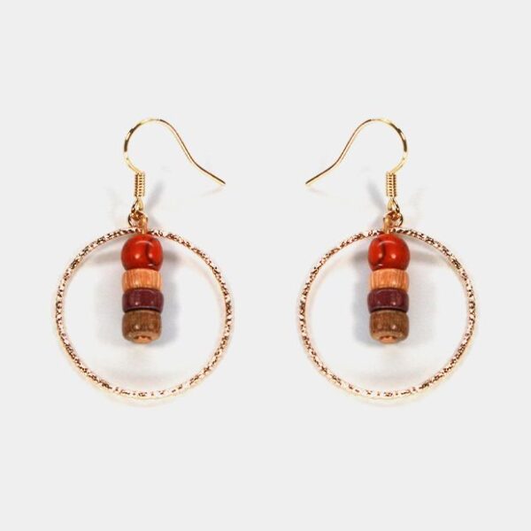 Gros plan sur des boucles d’oreilles Jenny en bois multicolore avec des apprêts dorés.