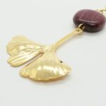 Bijoux Ginkgo doré Doly sur pochon en lin sauvage, alliant élégance artisanale et détails dorés pour femme.