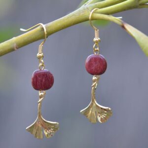 "Boucle d'oreille en bois d'amarante avec apprêts dorés, conception artisanale, vue de face.