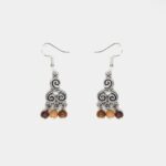 Boucles d’oreilles en bois multicolore avec symbole triskel argenté et fermoirs en métal sans nickel.