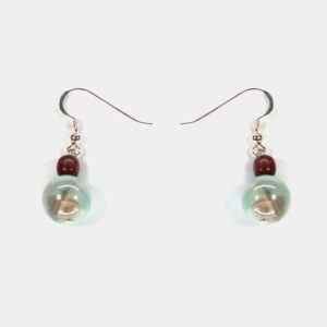 Gros plan sur les détails fins des boucles d’oreilles Eulalie, mettant en valeur le travail artisanal du bois et des apprêts en argent.