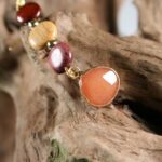 Détails des matériaux utilisés pour les boucles d'oreilles Maelys, incluant le bois d'amarante et le quartz rose.