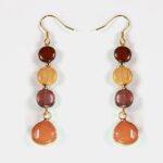 Boucles d'oreilles en quartz rose et bois doré Maelys, mettant en avant la finesse du design et les matériaux naturels.