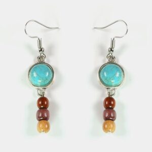 Bijoux artisanaux Maissa faits main en turquoise et bois précieux, posés sur un fond clair.
