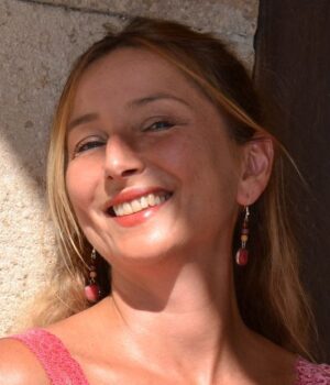 Femme portant des boucles d'oreilles en quartz cerise et bois, mettant en valeur la beauté naturelle des bijoux.