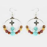 Paire de boucles d'oreilles légères en pierre turquoise et bois précieux, associant finesse et modernité.