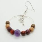 Boucles d’oreilles artisanales en bois précieux et pierre d’améthyste violacée, suspendues à des apprêts en métal argenté.