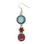 Un gros plan sur les boucles d’oreilles en bois étoile Hélios avec une perle ronde en amarante, une étoile en palissandre et un cabochon turquoise.