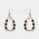 Vue rapprochée des détails des boucles d'oreilles mettant en évidence le travail artisanal et les matériaux naturels utilisés.