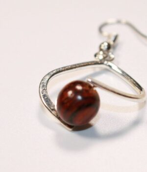 Boucles d'oreilles Falone en bois d'acajou artisanal avec un design élégant, présentées dans un fond neutre.